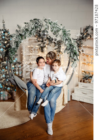 Happy children with mom sits in front of the Christmas tree 97187428
