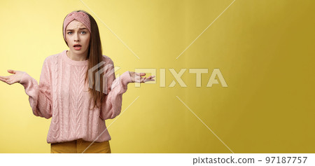 What big deal, why so fuss. Frustrated confused and clueless cute young pretty woman in knitted sweater, headband shrugging in dismay asking question unaware what happening 97187757