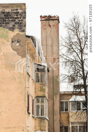 Long, icy icicles hang on the edge of the roof, spring or winter. 97189105