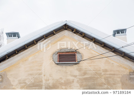 Two smoke, rectangular, exhaust pipes on the roof of an old house 97189184