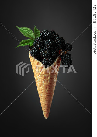 Fresh blackberries in a waffle cone. 97189428