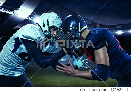 Start of competition. Two american football players in uniform standing face to face at the stadium with flashlights. Concept of sport, motion 97192444