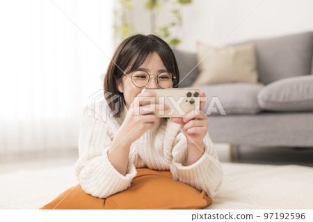 女人在客廳裡看智能手機 97192596