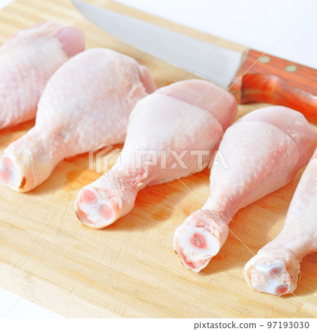 Fresh uncooked chicken meat drumsticks pieces and knife, baget ready to cook 97193030