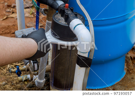 Maintenance performed by professional worker replacement of replaceable filters for cleaning water in outside near home 97193057