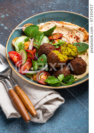 Close up of Middle Eastern Arab meal with fried falafel, hummus, vegetables salad Close up of Middle Eastern Arab meal with fried falafel, hummus, vegetables salad 97193457