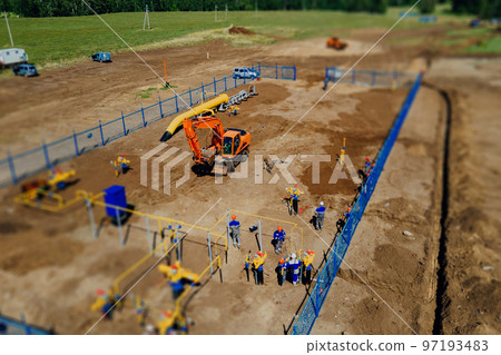 Aerial view excavator and construction workers working on construction site in open field. Pipe 97193483