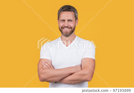 Happy man. Grizzled man smiling in casual white tshirt. Handsome man keeping arms crossed Happy man. Grizzled man smiling in casual white tshirt. Handsome man keeping arms crossed 97193899