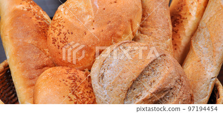 Fresh nutritious and golden colored bread homemade, in a wicker basket Fresh nutritious and golden colored bread homemade, in a wicker basket 97194454