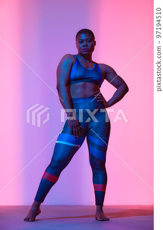 Body Positivity And Sport. Smiling Curvy Black Woman In Sportswear Free Copy Space For Advertisement, Standing Isolated On Neon Pink Studio Background, Banner 97194510