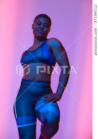 Body Positivity And Sport. Smiling Curvy Black Woman In Sportswear Free Copy Space For Advertisement, Standing Isolated On Neon Pink Studio Background, Banner 97194512