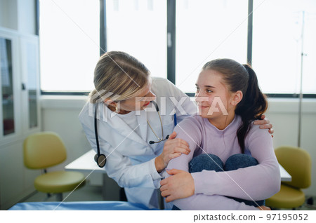 Close-up of doctor consoling teenage girl in her ambulance office. Close-up of doctor consoling teenage girl in her ambulance office. 97195052