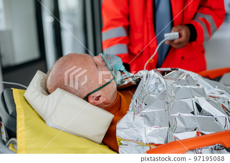 Rescuers taking care of patient from ambulance. 97195088