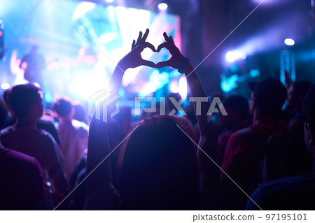 People taking photographs with smart phone during a music festival. Fans enjoying rock concert with light. 97195101