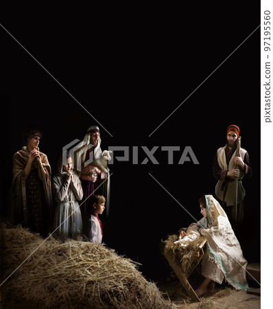 Mary sits in the stable near the manger with the baby Mary sits in the stable near the manger with the baby 97195560