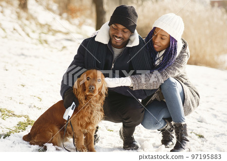 People walks outside. Winter day. African couple with dog. People walks outside. Winter day. African couple with dog. 97195883