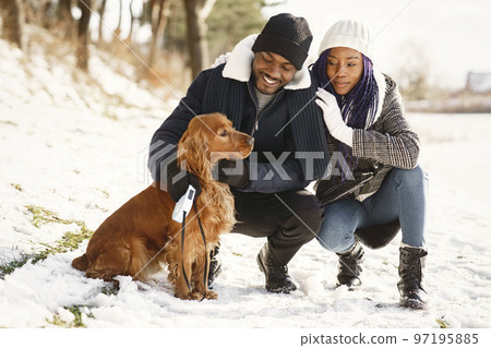People walks outside. Winter day. African couple with dog. People walks outside. Winter day. African couple with dog. 97195885
