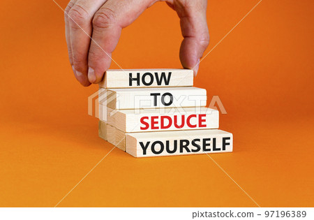 How to seduce yourself symbol. Concept word How to seduce yourself on wooden blocks. Businessman hand. Beautiful orange table orange background. Business and how to seduce yourself concept. Copy space 97196389