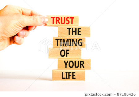Timing of your life symbol. Concept words Trust the timing of your life on wooden blocks on a beautiful white table white background. Businessman hand. Business trust the timing of your life concept 97196426