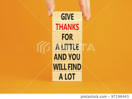Give thanks symbol. Concept words Give thanks for a little and you will find a lot on wooden blocks. Beautiful orange background copy space. Businessman hand. Business motivational give thanks concept 97196443