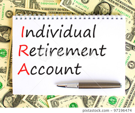 IRA individual retirement account symbol. Concept words IRA individual retirement account on white note on background from dollar bills. Business IRA individual retirement account concept. Copy space IRA individual retirement account symbol. Concept words IRA individual retirement account on white note on background from dollar bills. Business IRA individual retirement account concept. Copy space 97196474