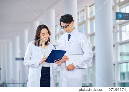 Medical image of men and women in lab coats meeting at the hospital Medical image of men and women in lab coats meeting at the hospital 97196574