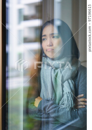 Portrait of sad ill korean woman looking out of the window, staying at home due to coronavirus, being sick and cant leave house Portrait of sad ill korean woman looking out of the window, staying at home due to coronavirus, being sick and cant leave house 97196615