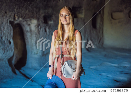 Young woman exploring valley with rock formations and fairy caves near Goreme in Cappadocia Turkey 97196879