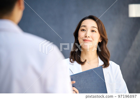 Medical image of men and women in lab coats meeting at the hospital Medical image of men and women in lab coats meeting at the hospital 97196897