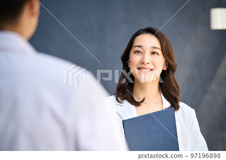 Medical image of men and women in lab coats meeting at the hospital 97196898