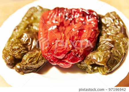 Roasted red and green peppers on a white plate 97196942