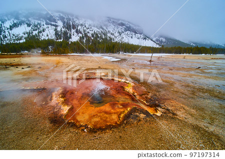 Yellowstone in winter with acidic colorful pools and steam 97197314