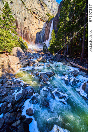 Yosemite Lower Falls in early morning with frosty rocks and icy river 97197357