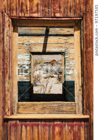 View through abandoned ghost town train with desert structure in window 97197585