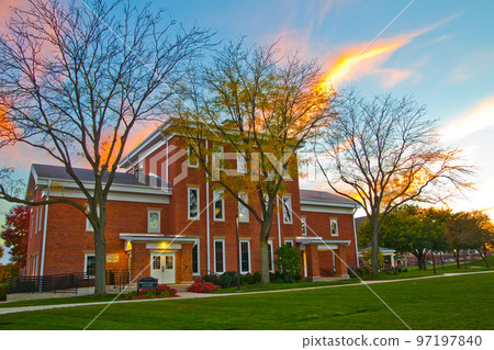 Colonial style red brick building with lush green lawn at sunset Colonial style red brick building with lush green lawn at sunset 97197840