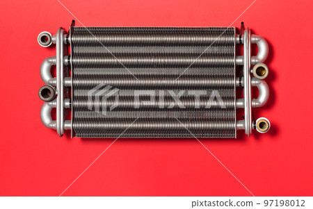 Metal section of a heating radiator on a red background Metal section of a heating radiator on a red background 97198012