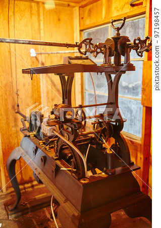 Close-up of an antique machine in a wooden room with orange lighting 97198457