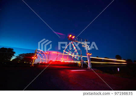 Railroad crossing and a speeding train in motion at dusk 97198635