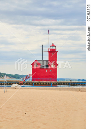 View of red lighthouse in Michigan with sandy beaches and blue railing View of red lighthouse in Michigan with sandy beaches and blue railing 97198803