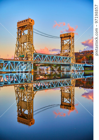 Houghton sunrise of soft blues and purple and pink clouds with glassy surface of river water and the lift bridge Houghton sunrise of soft blues and purple and pink clouds with glassy surface of river water and the lift bridge 97198857