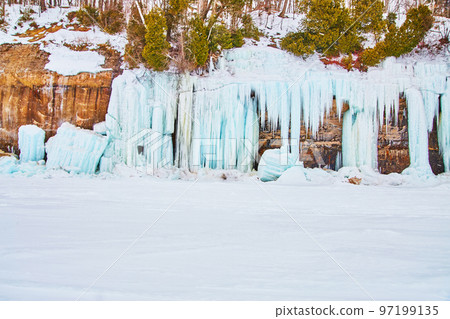 Winter cliffs on lake covered in stunning blue ice formations 97199135