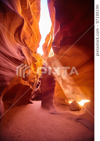 Light filters in at an angle through an orange canyon Light filters in at an angle through an orange canyon 97199190