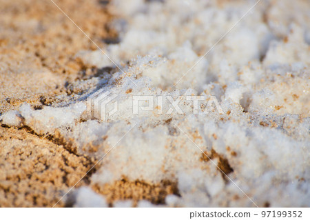 Macro of snow on sandy beach Macro of snow on sandy beach 97199352