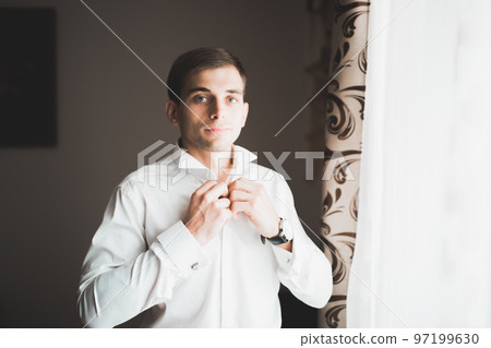 Young handsome man relaxing at his apartment in a hotel after business meeting 97199630