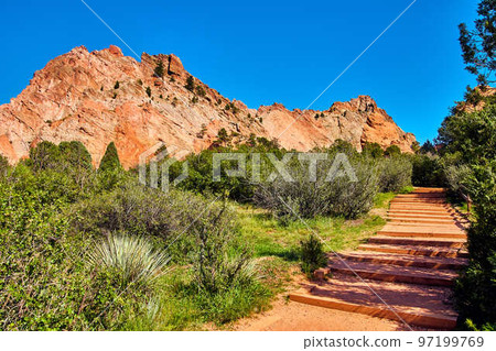 Walking desert path steps with desert plants and red mountains with blue sky background Walking desert path steps with desert plants and red mountains with blue sky background 97199769