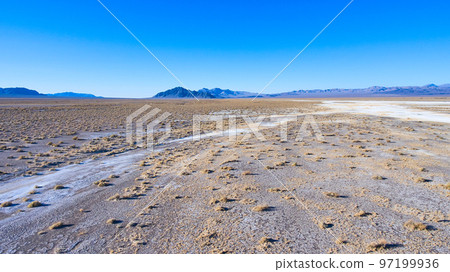 Aerial of open desert landscape with mountains in distance 97199936
