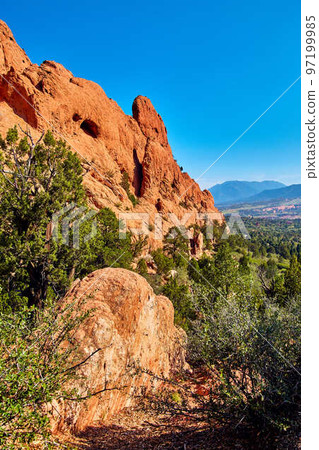 Vertical mountain view in desert with pillars of red rock Vertical mountain view in desert with pillars of red rock 97199985
