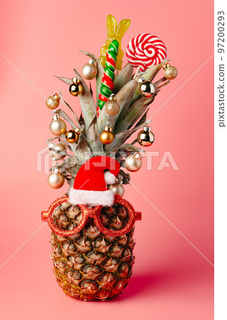 Creative pineapple with Christmas decorations on studio background 97200293