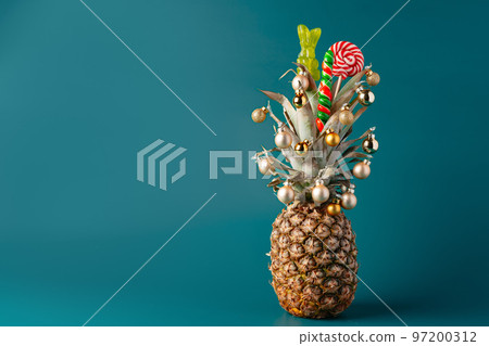Creative pineapple with Christmas decorations on studio background 97200312