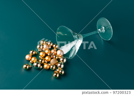 Glass with Christmas decorations on dark green background Glass with Christmas decorations on dark green background 97200323